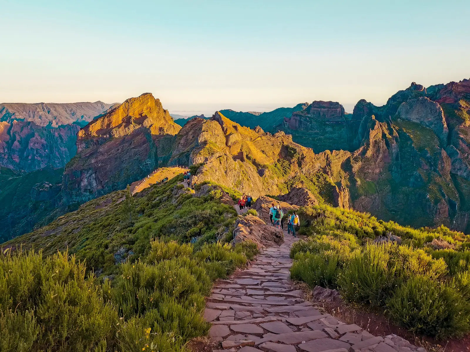 Hikers on the Pico do Areeiro trail, with the peaks behind