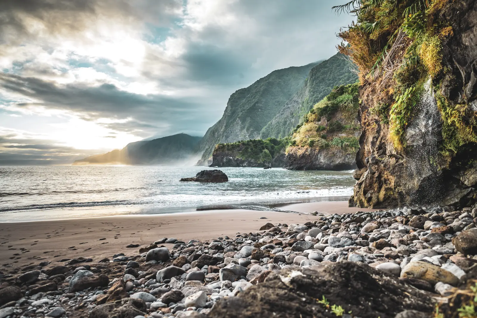 Praia de areia preta do Seixal ao amanhecer, com a costa norte ao fundo