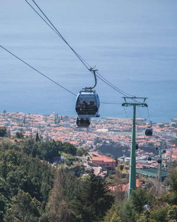 Cabine do teleférico do Funchal sobre a cidade, com o mar ao fundo